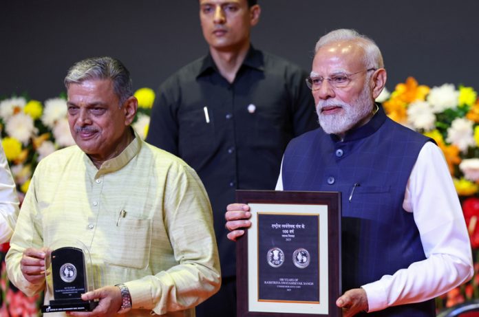PM Modi releasing a coin and stamp during RSS centenary celebrations
